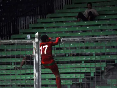 Begitu peluit panjang dibunyikan, Ferdinand Sinaga langsung memanjat pagar pembatas penonton di Stadion GBK Jakarta, (11/5/2014). (Liputan6.com/Helmi Fithriansyah)