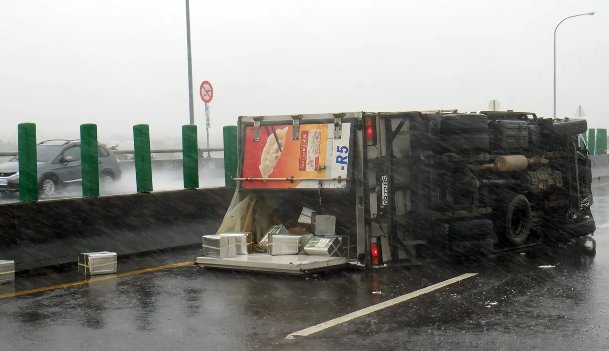 Sebuah truk terbalik di jalan saat topan super meranti disertai hujan dan angin kencang melanda Pingtung, Taiwan selatan, Rabu (14/9). Membawa angin kencang, hujan deras dan banjir, topan ini bergerak dengan kecepatan 216 kilometer per jam. (Sam YEH/AFP)