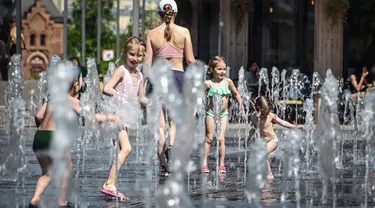 Orang-orang menikmati musim semi yang panas dengan mandi di air mancur di Moskow, Rusia, Selasa (18/5/2021). Suhu di Moskow telah mencapai 31 derajat Celcius. (Alexander NEMENOV/AFP)