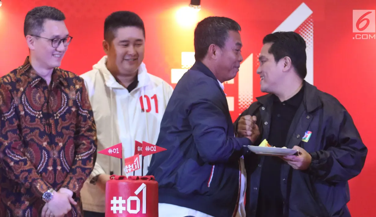 Ketua Tim Kampanye Nasional (TKN) Jokowi-Ma’ruf Amin, Erick Thohir berjabat tangan dengan politisi PDIP, Prasetyo Edi Marsudi usai pemotongan tumpeng pada peluncuran #01 Official Merchandise di Jakarta Pusat, Jumat (25/1). (Liputan6.com/Angga Yuniar)
