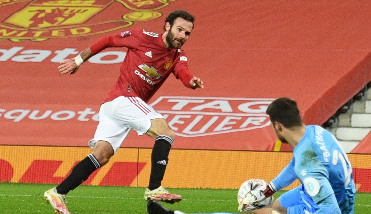 Kiper Watford, Daniel Bachmann (kanan) mementahkan tendangan gelandang Manchester United, Juan Matta dalam laga babak ke-3 Piala FA 2020/21 di Old Trafford, Sabtu (9/1/2021). Watford kalah 0-1 dari Manchester United. (AFP/Oli Scarff/Pool)