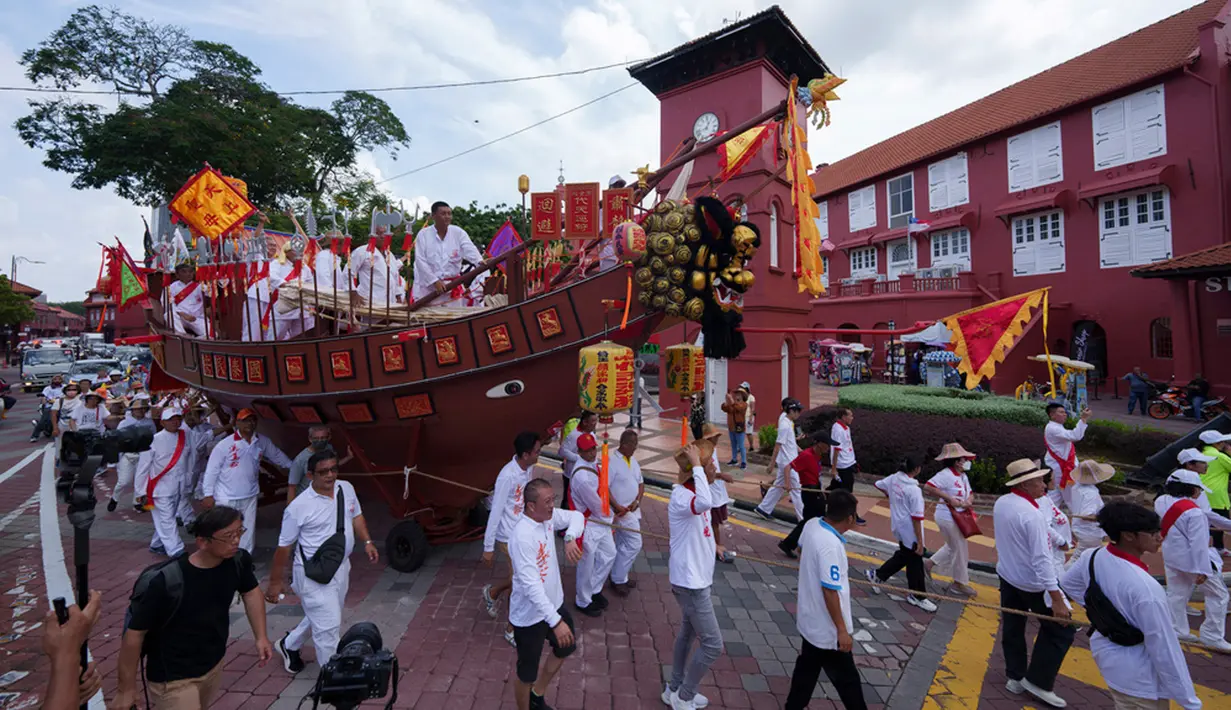 Penuh dengan ritual keagamaan dan budaya, Kapal Wangkang meliuk-liuk melewati rute 9 kilometer (6 mil) di kota bersejarah Malaka dengan 22 perhentian di mana para pendeta melakukan ritual pembersihan untuk mengusir roh jahat dan pengaruh negatif lainnya. (AP Photo/Vincent Thian)