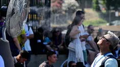 Sebuah kipas angin menyemprotkan air di sepanjang gerbang Colosseum, Roma untuk menyegarkan para turis pada tanggal 11 Juli 2024. (Tiziana FABI/AFP)