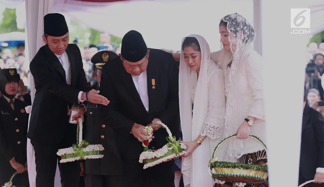 Presiden ke-6 RI Susilo Bambang Yudhoyono beserta putra dan menantunya menabur bunga di atas pusara Ani Yudhoyono di TMP Kalibata, Jakarta, Minggu (2/6/2019). Ani Yudhoyono meninggal dunia di National University Hospital Singapura pada 1 Juni 2019 karena kanker darah. (Fimela.com/Deki Prayoga)