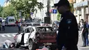 Petugas berdiri dekat mobil yang ditumpangi jurnalis investigasi ternama, Pavel Sheremet yang tewas di Kiev, Ukraina, Rabu (20/7). Jurnalis Ukrayina Pravda itu sedang mengendarai mobil ke tempat kerja ketika mobil tersebut meledak. (Sergei SUPINSKY/AFP)