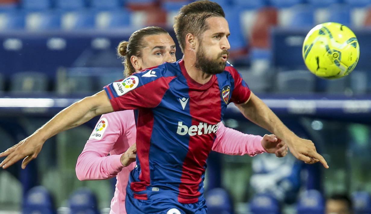 Gelandang Levante, Jorge Miramon (depan) menguasai bola dibayangi gelandang Barcelona, Antoine Griezmann dalam laga lanjutan Liga Spanyol 2020/2021 pekan ke-36 di Ciutat de Valencia Stadium, Valencia, Selasa (11/5/2021). Levante bermain imbang 3-3 dengan Barcelona. (AP/Alberto Saiz)