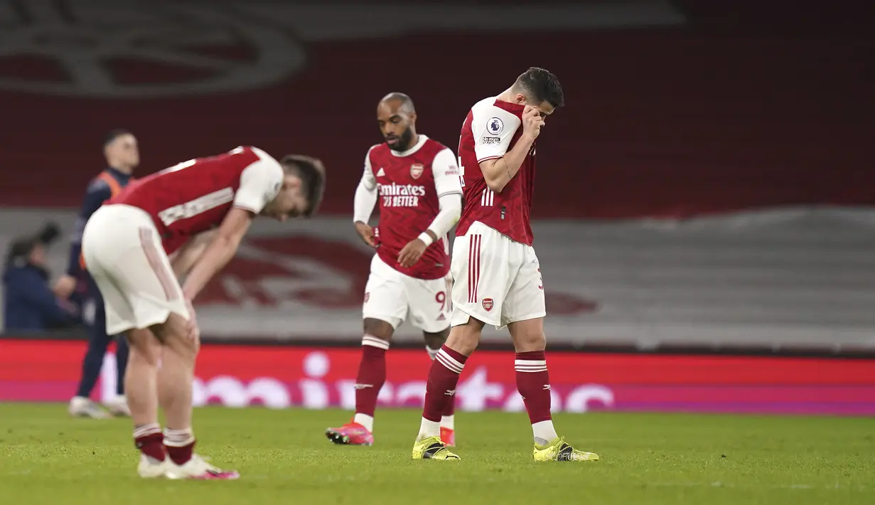 Para pemain Arsenal bereaksi atas kekalahan mereka atas Manchester City pada akhir pertandingan lanjutan Liga Inggris di Emirates Stadium, Minggu (21/2/2021). Manchester City kian mengokohkan posisinya di puncak klasemen setelah menang 1-0 di kandang Arsenal. (John Walton / Pool via AP)