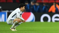Striker Tottenham Hotspur, Son Heung-Min berjongkok di lapangan saat menjamu Juventus pada leg kedua babak 16 besar Liga Champions di Wembley, Kamis (8/3). Kekalahan dari Juventus membuat Heung-Min terlihat begitu emosional. (Glyn KIRK/AFP)