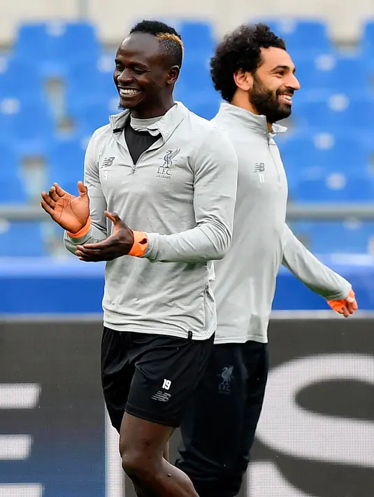 Senyum pemain Liverpool, Mohamed Salah (kanan) dan Sadio Mane saat sesi latihan di Stadion Olimpico, Roma, Italia (1/5). Liverpool unggul 5-2 menghadapi AS Roma pada leg pertama semifinal Liga Champions. (Ettore Ferrari / ANSA via AP)