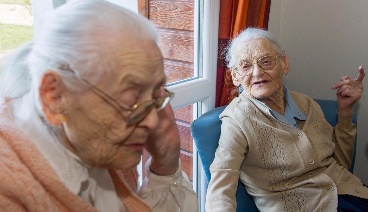 Paulette Olivier (kanan) dan Simone Thiot berbincang saat berada di Ephad "Les Bois Blancs", Prancis (13/2). Paulette dan Simone perempuan berusia 104 tahun ini diyakini sebagai wanita kembar tertua di dunia. (AFP PHOTO/GUILLAUME souvent)