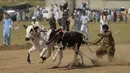 Para penonton menyaksikan dan bersorak-sorai saat para petani berlomba dengan sapi jantan mereka dalam kompetisi balapan sapi tradisional di pinggiran Islamabad, Pakistan, Minggu (27/6/2021). Ditengah pandemi covid-19, balapan sapi ini disaksikan banyak penonton. (Farooq NAEEM/AFP)