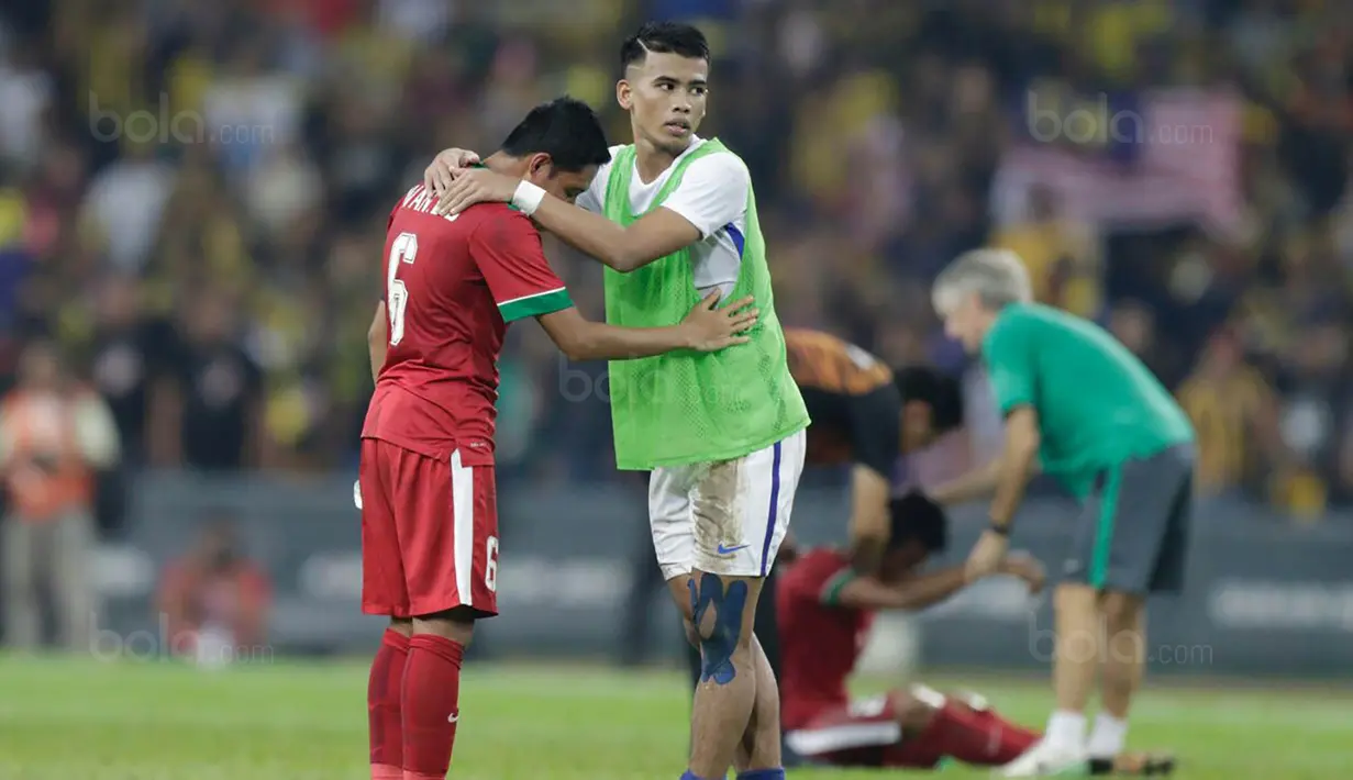 Pemain Malaysia berusaha menenangkan kapten Indonesia, Evan Dimas usai takluk dari Malaysia pada laga semifinal Sea Games 2017 di Stadion Shah Alam, Selangor, Sabtu (26/8/2017). Malaysia menang 1-0 atas Indonesia. (Bola.com/Vitalis Yogi Trisna)