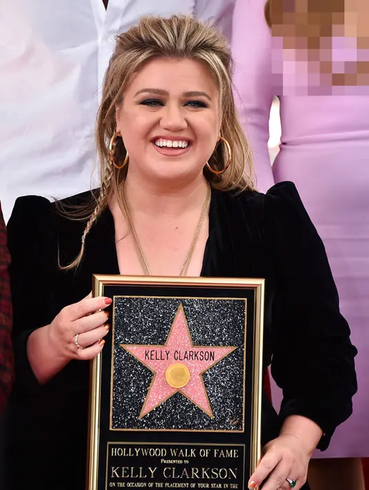 <p>Penyanyi dan pembawa acara talk show Kelly Clarkson berpose dengan replika bintang Hollywood Walk of Fame di Los Angeles, Amerika Serikat, 19 September 2022. Setelah 20 tahun memenangkan musim perdana acara kompetisi menyanyi, Kelly Clarkson akhirnya diakui sebagai bintang di Hollywood Walk of Fame. (Photo by Jordan Strauss/Invision/AP)</p>