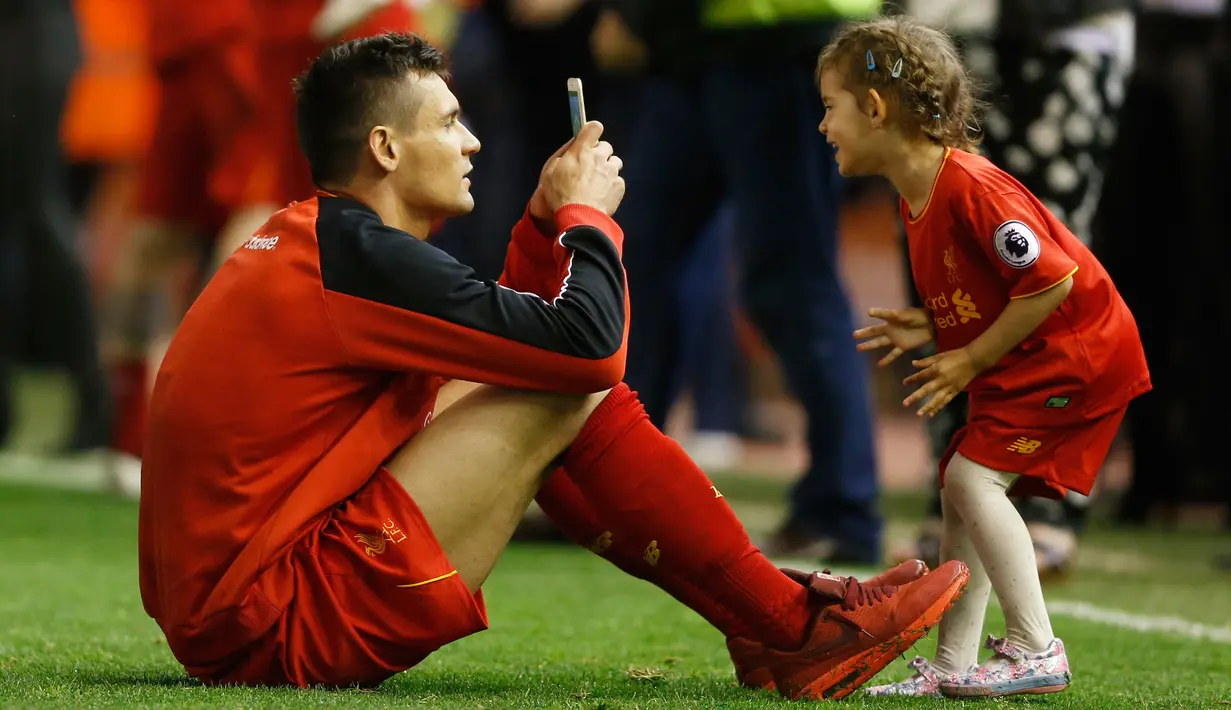 Bek Liverpool Dejan Lovren mengambil gambar putrinya saat salam penghormatan usai bertanding melawan Chelsea pada pertandingan Liga Inggris di Anfield, Liverpool, 12 Mei 2016. (Reuters / Carl Recine)