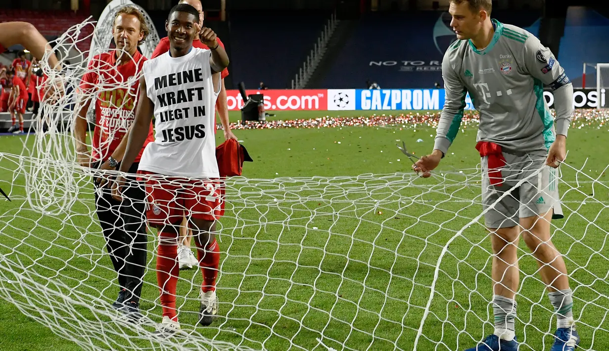 Kiper Bayern Munchen, Manuel Neuer dibantu rekannya membawa jaring gawang saat merayakan timnya meraih trofi Liga Champions usai mengalahkan PSG pada pertandingan final di stadion Luz di Lisbon (23/8/2020). Munchen menang tipis atas PSG 1-0. (AFP/Lluis Gene)