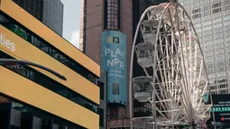 Biangalala raksasa yang baru dibuka berputar di Times Square, Manhattan, New York City, Rabu (25/8/2021). Diberi nama Times Square Wheel, wahana ini terletak di alun-alun Broadway, di sekitar 47th dan 48th Street. (Scott Heins/Getty Images/AFP)