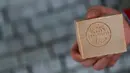 Pengusaha sabun zaitun khas Aleppo menunjukkan sabun yang telah berubah warna usai menjalani proses pengeringan, Paris, Kamis (22/12). Kota Aleppo yang tak lagi aman membuat pengusaha sabun ini pindah ke Paris. (REUTERS / Christian Hartmann)