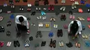 Staf medis mengatur instalasi seni dengan 321 pasang sepatu yang menandakan kematian akibat merokok dalam rangka memperingati Hari Tanpa Tembakau Sedunia di Pusat Paru Filipina, Quezon City, pinggiran kota Manila, Filipina, Selasa (31/5/2022). (JAM STA ROSA/AFP)