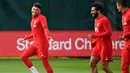 Gelandang Liverpool, Alex Oxlade-Chamberlain (kiri) tertawa bersama Mohamed Salah dan Dejan Lovren selama sesi latihan tim di Melwood di Liverpool, Inggris barat laut (22/10/2019). Liverpool akan bertanding melawan wakil Belgia, Genk pada Grup E Liga Champions di Luminus Arena. (AFP/Paul Ellis)
