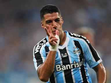 Penyerang Gremio Luis Suarez merayakan gol yang dicetaknya ke gawang Sao Luiz pada ajang Recopa Gaucha di stadion Arena do Gremio di Porto Alegre, Brasil, Selasa (17/1/2023). Luis Suarez menunjukkan ketajamannya di laga perdananya bersama Gremio dengan langsung mencetak gol. (SILVIO AVILA / AFP)