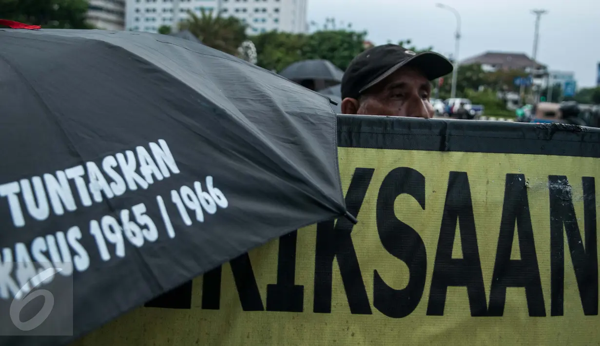 Sejumlah peserta kamisan membawa payung saat aksi Kamisan ke-482 di depan Istana Merdeka, Jakarta, Kamis (23/2). Mereka menuntut Presiden Jokowi untuk menuntaskan segala kasus pelanggaran HAM. (Liputan6.com/Gempur M Surya) 