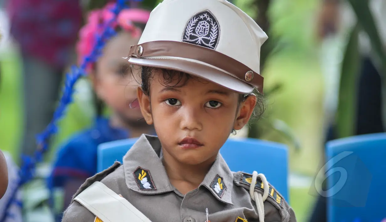 Ekspresi lucu seorang murid TK Sekolah Alternatif untuk Anak Jalanan (SAAJA) saat mengenakan pakaian adat dalam rangka memperingati Hari Kartini di kawasan Kuningan, Jakarta, Selasa (21/4/2015). (Liputan6.com/Faizal Fanani)