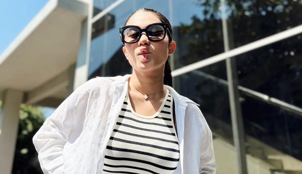 Pakai crop top dan dipadukan dengan kemeja putih, Azizah Salsha tampil simpel. Kalung yang melingkar di lehernya mendukung penampilan Azizah jadi lebih menarik. Kacamata hitam yang dikenakan Azizah juga sangat cocok karena terlihat cuaca Solo pada saat itu sedang panas. Pamer duck face saat berfoto, tak sedikit netizen gemas dengan istri Pratama Arhan ini. (Liputan6.com/IG/@arhanazizah.official)