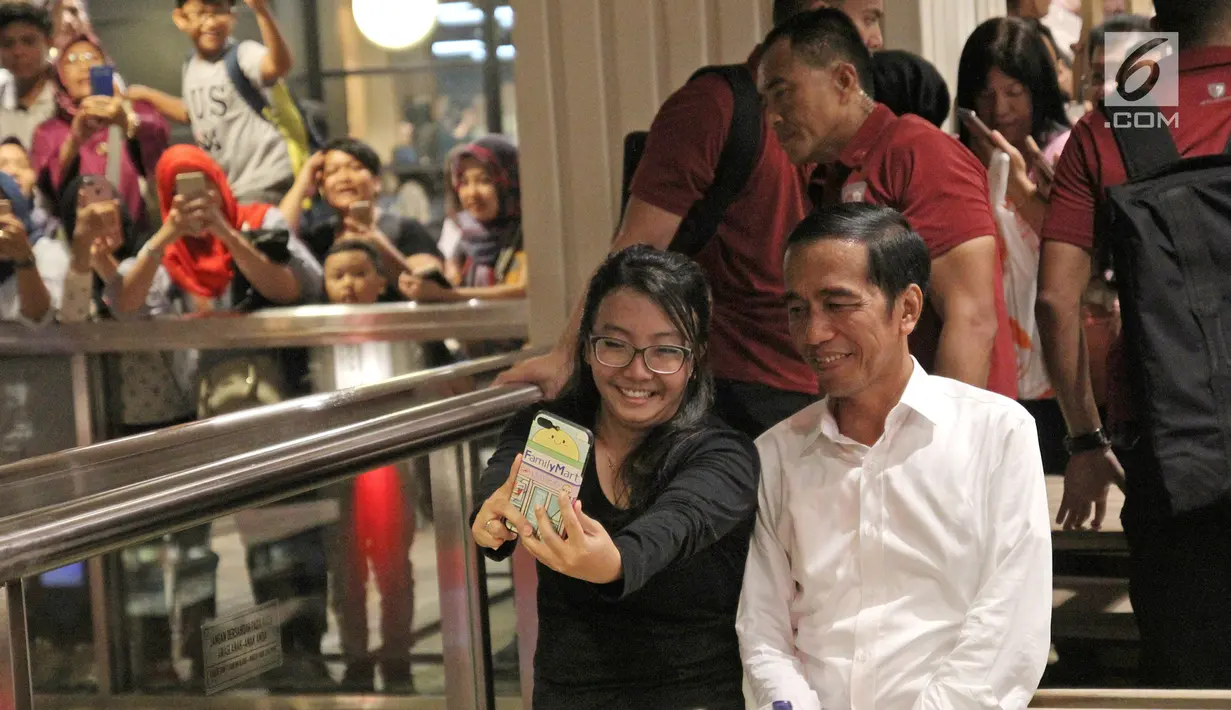 Calon Presiden nomor urut 01, Joko Widodo atau Jokowi berswafoto dengan pengunjung saat berkunjung di Grand Indonesia, Jakarta, Sabtu (20/4). Kedatangan Jokowi berkemeja putih bersama Ketua TKN Erick Thohir dan Wishnutama untuk makan siang bersama. (Liputan6.com/Herman Zakharia)