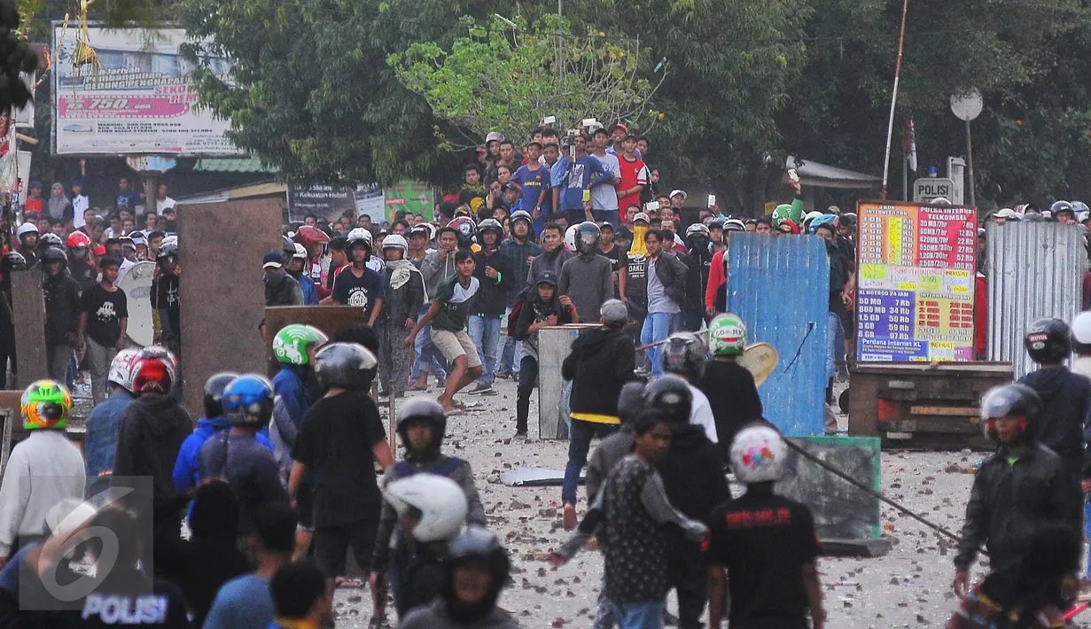 Dua kelompok warga terlibat tawuran di dekat Stasiun Manggarai, Jakarta Selatan, Minggu (8/1).  Puluhan orang terlihat membawa senjata tajam, bongkahan batu dan petasan. (Liputan6.com/Angga Yuniar)