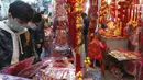 Orang-orang membeli dekorasi untuk merayakan Tahun Baru Imlek di Hong Kong, Minggu (30/1/2022). Tahun Baru China atau Imlek jatuh pada 1 Februari (AP Photo/Vincent Yu)