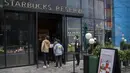 <p>Orang-orang yang memakai masker berbaris di kafe Starbucks yang buka hanya untuk pesanan bawa pulang setelah banyak bisnis diperintahkan untuk tutup sebagai bagian dari pembatasan COVID-19 di distrik Chaoyang di Beijing, Sabtu, 14 Mei 2022. China dengan tegas menolak kritik terhadap kebijakan "nol-COVID" tanpa kompromi. (AP Photo/Mark Schiefelbein)</p>