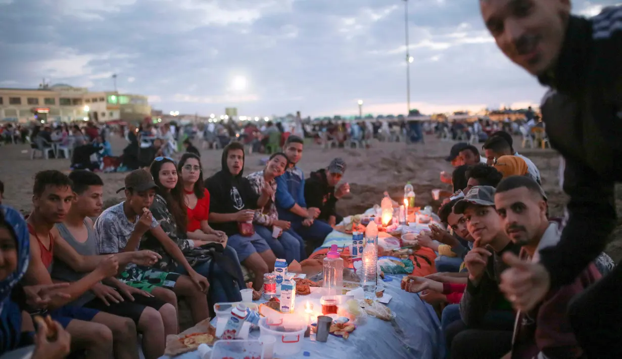 Warga bersiap buka puasa di pantai Rabat, Maroko (9/6). Selama Ramadan, banyak warga Maroko berkunjung ke pantai menikmati angin Atlantik dan menikmati pemandangan laut. (AP Photo/Mosa'ab Elshamy)