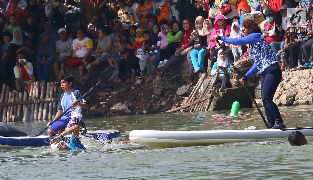 Menteri Kelautan dan Perikanan Susi Pudjiastuti dan Wakil Gubernur DKI Jakarta Sandiaga Uno saat bertanding melintasi danau sepanjang 1k selama Festival Danau Sunter di Jakarta, Minggu (25/2). (Liputan6.com/Angga Yuniar)