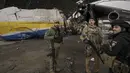 Prajurit Ukraina berdiri dekat pesawat Antonov An-225 Mriya di bandara Antonov di Hostomel, 2 April 2022. Di pintu masuk Bandara Antonov, pasukan menjaga posisinya, tanda mereka memegang kendali penuh atas landasan pacu yang coba diserbu Rusia di hari-hari pertama perang. (AP Photo/Vadim Ghirda)