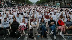 Orang-orang menonton film gratis yang diputar di ruang terbuka di jalan Champs Elysees, Paris (7/7/2019). Pemutaran bioskop luar ruangan gratis di Paris musim panas ini menayangkan film Prancis dengan teks bahasa Inggris, untuk membantu Anglophones mengikuti budaya Prancis. (AP Photo/Michel Euler)