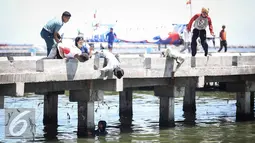 Warga dan petugas TNI AL menolong anak kecil yang terjatuh ke laut di dermaga Muara Angke, Jakarta, Kamis (24/3). Akibat kelalaian ibunya seorang anak tercebur ke laut dan langsung di selamatkan warga dan prajurit TNI AL. (Liputan6.com/Faizal Fanani)