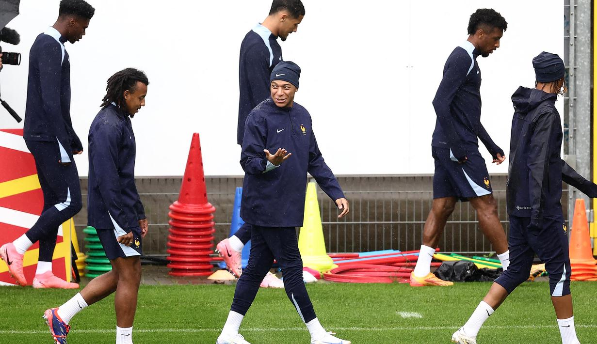 Penyerang Prancis, Kylian Mbappe (tengah-depan) berbicara dengan Jules Kounde (kiri) selama sesi latihan MD-1 di Stadion Home Deluxe Arena, Paderborn, Jerman, pada 30 Juni 2024. (FRANCK FIFE/AFP)