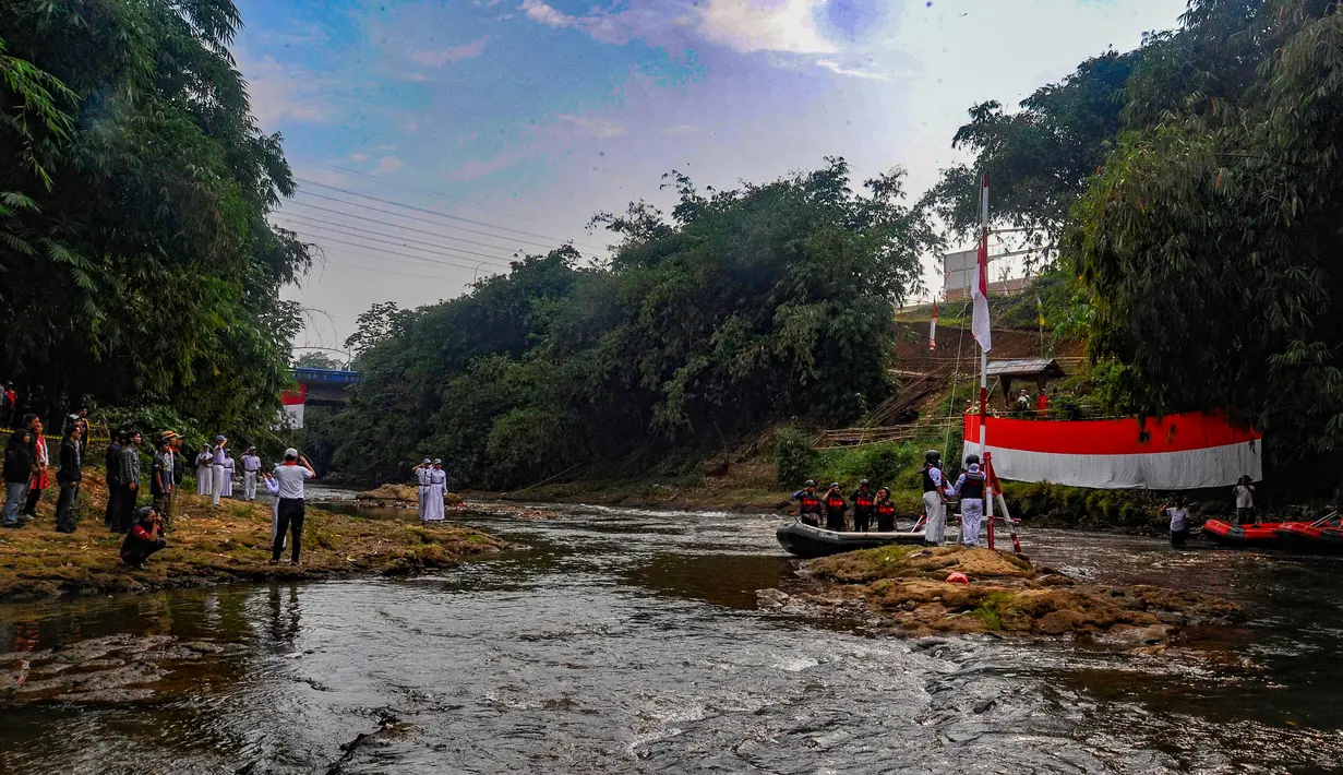 Peserta mengikuti upacara pengibaran bendera, di Sungai Ciliwung kawasan GDC, Depok, Jawa Barat, Sabtu (17/8/2024). (merdeka.com/Arie Basuki)