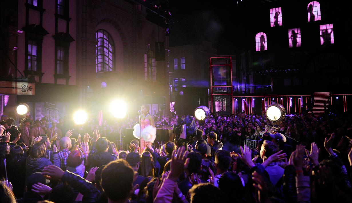 Penonton menikmati lagu yang dibawakan Ariana Grande saat MTV Movie Awards 2016 di Warner Bros Studios, California, USA (10/4). Ariana tampil seperti Marilyn Monroe dengan gaun merah muda. (AFP/Alberto E. Rodriguez)