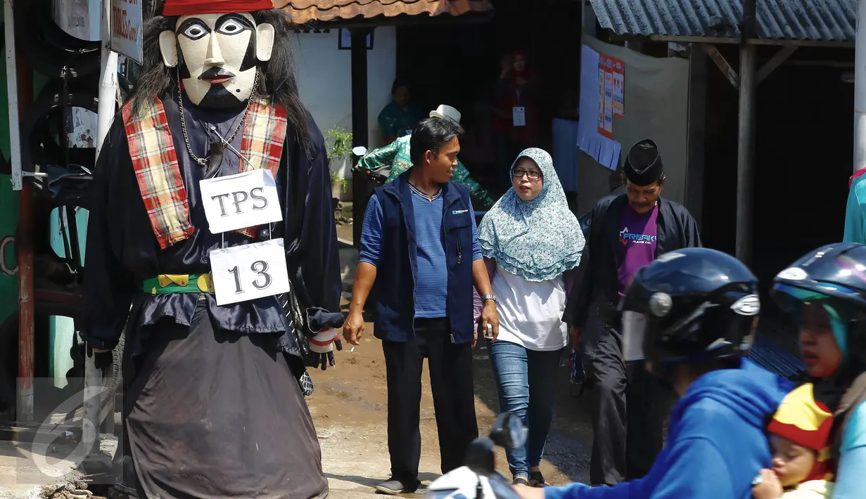 Boneka ondel-ondel tampak terpajang di pintu masuk TPS 13 Kelurahan Serua, Tangerang Selatan, Rabu (9/12). Jutaan warga Tangsel mengikuti hak suaranya untuk memilih 3 pasangan calon dalam Pilkada Serentak. (Liputan6.com/Fery Pradolo)