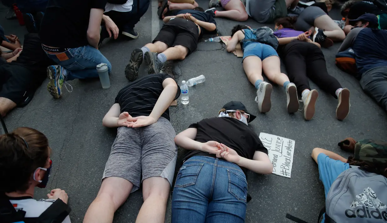 Demonstran berbaring di tanah dengan tangan seolah terikat di belakang punggung mereka ketika memprotes kematian George Floyd di Washington, Rabu (3/6/2020). Aksi tersebut menyimbolkan momen terakhir Floyd saat lehernya ditindih lutut oleh polisi Minneapolis pada 25 Mei lalu. (AP/Carolyn Kaster))