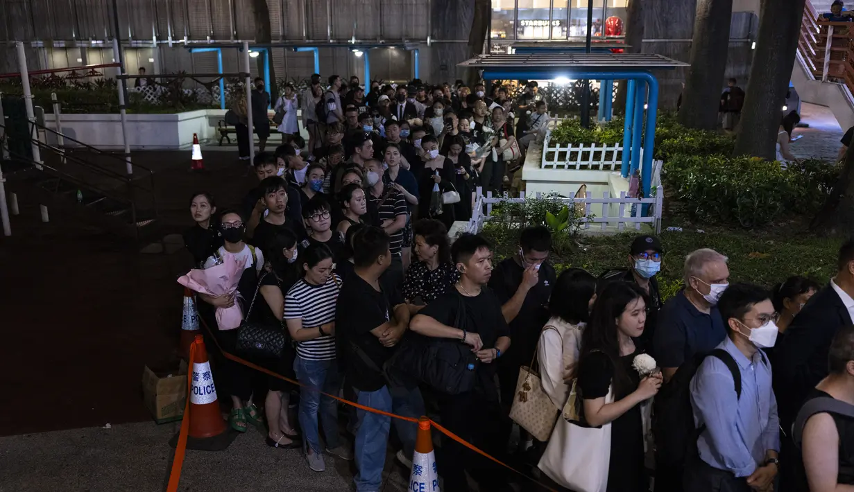Anggota masyarakat berbaris untuk memberikan penghormatan kepada penyanyi dan penulis lagu Coco Lee di luar rumah duka di Hong Kong, Senin, 31 Juli 2023. Lee meninggal 5 Juli pada usia 48 tahun. (AP Photo/Louise Delmotte)