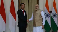 Presiden Joko Widodo (Jokowi) berjabat tangan dengan PM India Narendra Modi sebelum melakukan pertemuan bilateral di Hyderabad House, New Delhi, Senin (12/12). Ini pertama kalinya Presiden Jokowi melakukan kunjungan kenegaraan ke India. (Money SHARMA/AFP)