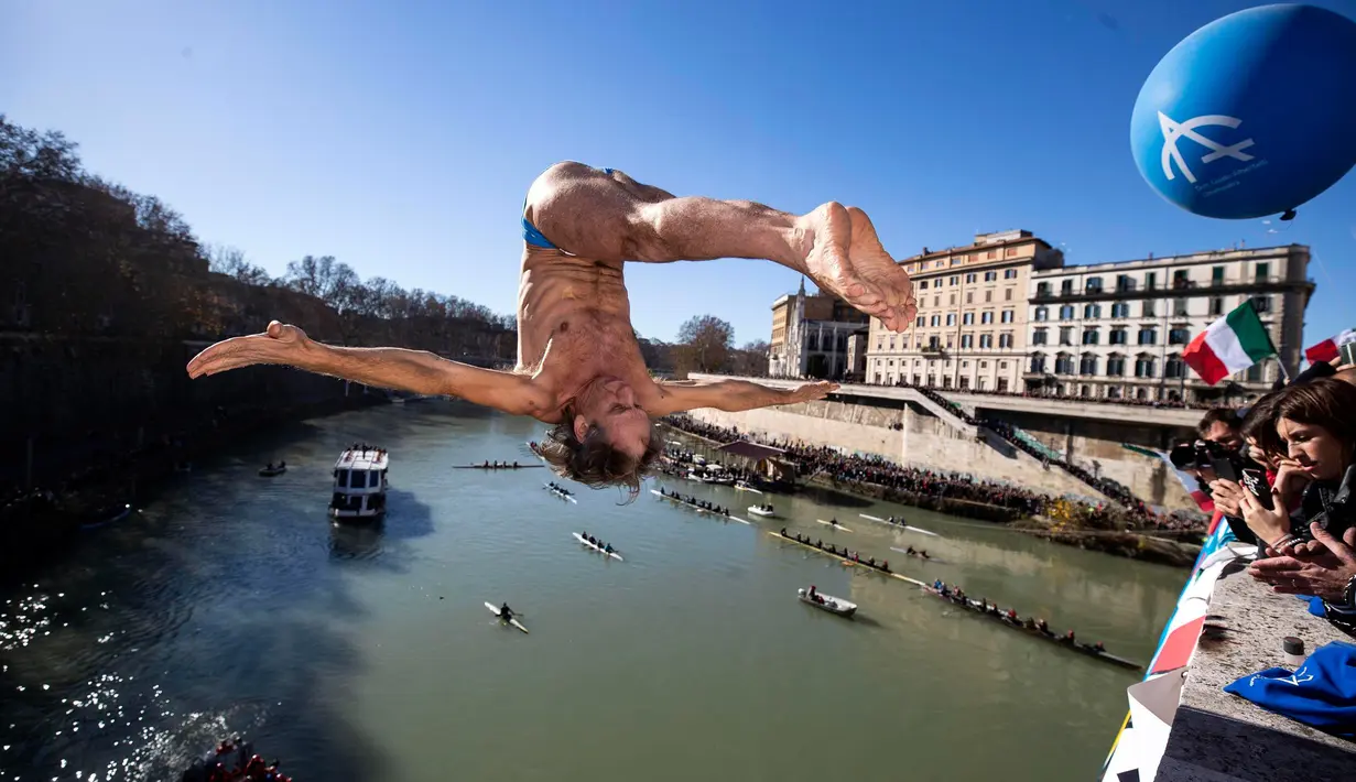 Marco Fois dari Italia melakukan terjun bebas ke sungai Tiber dari Jembatan Cavour di Roma, Selasa (1/1). Tradisi melompat dari jembatan setinggi 18 meter  dan menyelam ke sungai tersebut sebagai bentuk perayaan tahun baru. (AP/Riccardo De Luca)