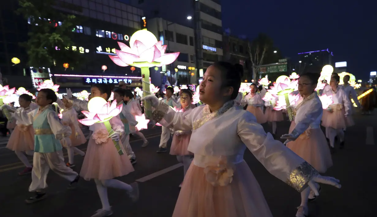 Sejumlah anak membawa lampion berbentuk teratai saat Lotus Lantern Festival di Seoul, Korea Selatan, Sabtu (29/4). Parade ini bagian dari jelang perayaan ulang tahun Buddha yang jatuh pada 3 Mei 2017. (AP Photo / Lee Jin-man)