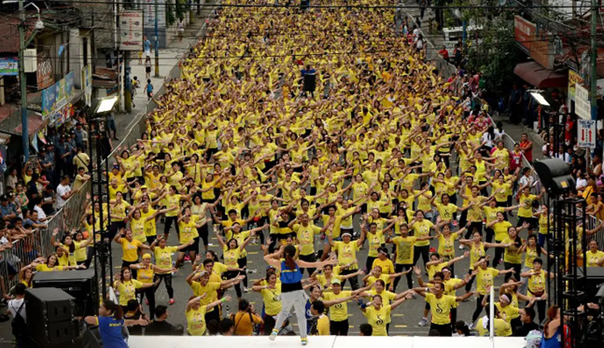 Seorang instruktur memimpin gerakan saat kelas zumba terbesar yang diadakan di sepanjang jalan utama Manila, Filipina, Minggu (19/7/2015). Warga Filipina memecahkan rekor Guinness World Records dengan peserta mencapai 12, 975. (REUTERS/Lorgina Minguito)