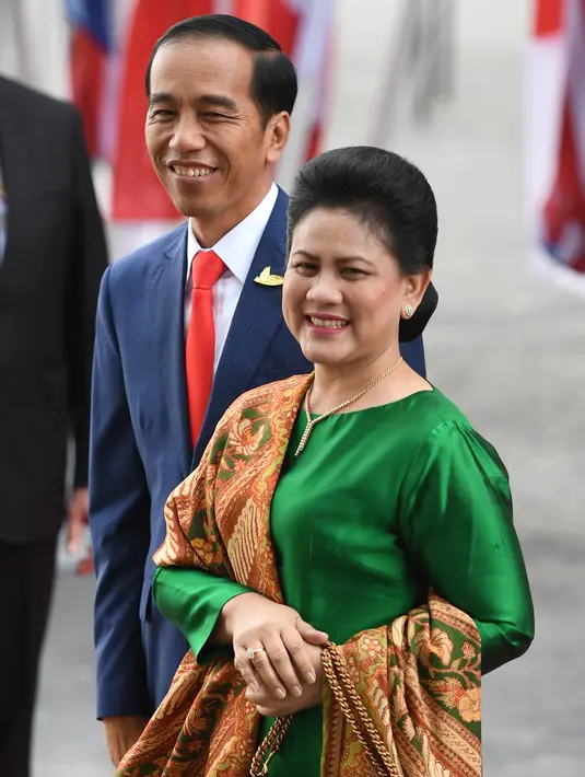 Presiden RI, Joko Widodo didamping Ibu Negara Iriana Widodo tersenyum saat tiba menghadiri KTT G20 di aula Elbphilharmonie di Hamburg, Jerman, (7/7). Sejumlah pemimpin negara berkumpul dalam KTT G20 pada 7-8 Juli 2017. (AFP Photo/Patrik Stollarz)