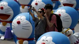 Sejumlah wisatawan saat berselfie di antara patung – patung Doraemon, Seoul, Korea Selatan,Senin (31/8/2015). Pameran ini berlangsung dari 28 Agustus sampai 4 oktober. (REUTERS/Kim Hong – Ji)