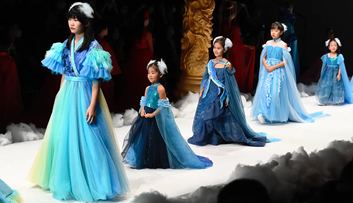 Model cilik berjalan di catwalk membawakan koleksi Jinshangyuyi karya desainer Wang Cong selama China Fashion Week di Beijing pada Kamis (9/9/2021). Gelaran pekan mode tersebut tetap digelar di tengah pandemi corona covid-19. (Giok GAO / AFP)