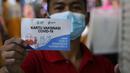 Pedagang melihatkan kartu vaksin di Pasar Tanah Abang, Jakarta, Selasa (27/7/2021). Dengan kembalinya dibuka Pasar Tanah Abang penjual mengeluhkan pembeli yang sangat sepi akibat peraturan baru yang mewajibkan menunjukkan kartu vaksin Covid-19 saat hendak berbelanja. (Liputan6.com/Johan Tallo)